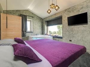 1 dormitorio con 1 cama grande de color púrpura y bañera en Villa Lavanda, en Nova Vas