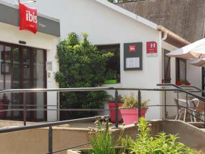 um edifício com vasos de plantas à sua frente em ibis Dieppe Le Val Druel em Dieppe