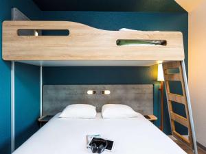 a bedroom with a bunk bed with a ladder at ibis budget Rueil Malmaison in Rueil-Malmaison