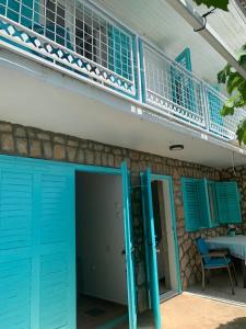 une maison avec une porte bleue et un balcon dans l'établissement Petite house, à Starigrad-Paklenica