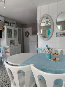 kuchnia z białym stołem i niebieskimi krzesłami w obiekcie Petite house w mieście Starigrad-Paklenica
