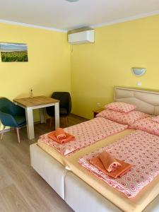 1 dormitorio con 2 camas, mesa y mesa en AndreaApartmanok, en Balatonfüred