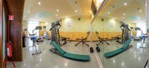 a gym with several tread machines in a room at Hotel Poseidonia Mare in Paestum
