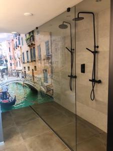 a bathroom with a shower with a view of a canal at Boutique Hotel de Valk in Valkenswaard