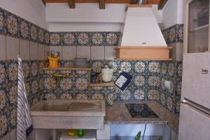 a kitchen with a sink and some tiles on the wall at ELBA Borgo di Latrano in Magazzini