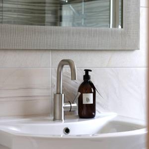 a bottle of soap sitting on a bathroom sink at Crow's Nest Glandore - 3 - Self Catering in Glandore