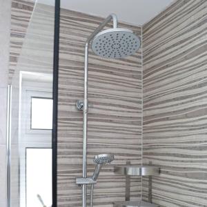 a shower in a bathroom with a wooden wall at Crow's Nest Glandore - 3 - Self Catering in Glandore