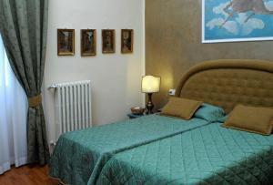 a bedroom with a bed with a green comforter at Relais Dante e Beatrice in Florence