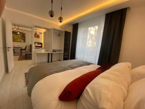 a bedroom with a large white bed with red pillows at Viva Suites Cappadocia in Nevşehir