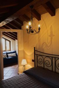 1 dormitorio con cama y lámpara de araña en Locanda OSTERIA LA MILONGA, en Agliano Terme