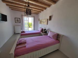 two beds with pink sheets in a room with a window at Villa Elena in Ornos +40 photos