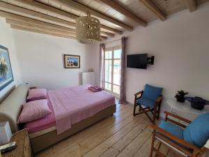 a bedroom with a bed and a couch and a tv at Villa Elena in Ornos