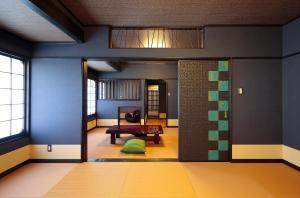 a hallway with a room with blue walls and a table at Goyokan in Izu