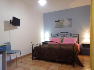 マッティナータにあるB&B Masseria Liberatoreのベッドルーム1室(ピンクの枕が付いたベッド1台付)