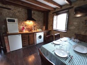 a kitchen with a table and a sink and a stove at APARTAMENTOS RURALES LA GALERÍA in Ribota