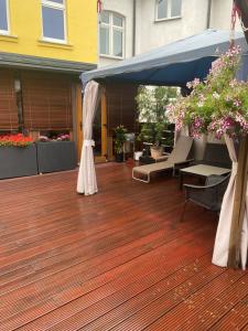 eine Terrasse mit einem blauen Sonnenschirm, Stühlen und Blumen in der Unterkunft Ferienwohnung mit Terrasse in Aue