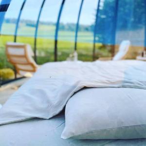 a bed with white pillows in a tent at Au Clair de ma Bulle in Marche-en-Famenne