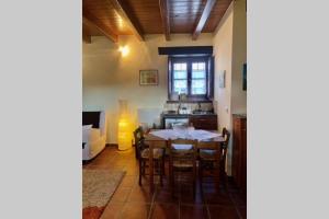 a dining room with a table and a kitchen at Periklis Guesthouse Anavriti. in Sparta
