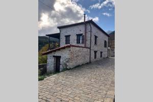 an old stone building on a cobblestone street at Periklis Guesthouse Anavriti. in Sparta