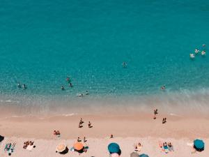 een groep mensen die op het strand in het water zwemmen bij Palazzo Mottola Tropea in Tropea