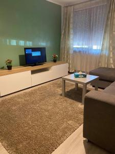 sala de estar con TV, sofá y mesa en Sweet Appartament, en Timisoara