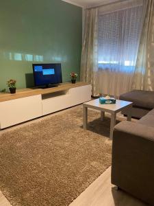a living room with a tv and a couch and a table at Sweet Appartament in Timişoara