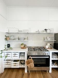 a white kitchen with a stove and white cabinets at Waukivory Estate - The Cottage 