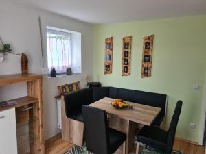 a dining room with a wooden table and black chairs at Ferienwohnung 's Stüble in Schonwald im Schwarzwald
