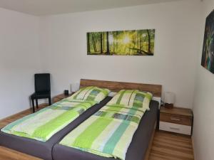 1 dormitorio con 1 cama y una foto en la pared en Ferienwohnung 's Stüble, en Schönwald