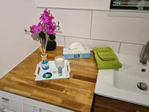 a bathroom counter with a sink and flowers on it at Ferienwohnung 's Stüble in Schonwald im Schwarzwald +16 photos