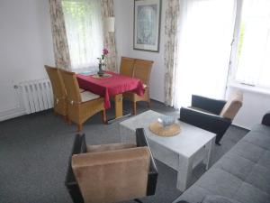 uma sala de estar com mesa e cadeiras em Ferienhaus Görsdorf Berlin em Berlim