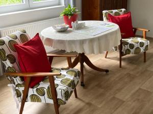 a dining room table with two chairs and a table with a white tablecloth at Hejnice Retreat in Hejnice