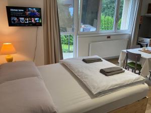 sypialnia z białym łóżkiem i 2 ręcznikami w obiekcie Hejnice Retreat w mieście Hejnice