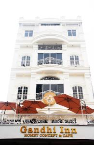 un bâtiment blanc avec un panneau devant lui dans l'établissement Gandhi Inn, à Medan