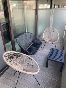 3 chaises et un banc sur un balcon dans l'établissement Studio Ascot, à Ostende