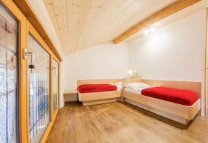 dwa łóżka w pokoju z oknem w obiekcie Zagler Appartments w mieście Tirolo