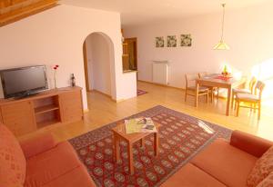 Una sala de estar con un sofá, un televisor y una mesa. en Zagler Appartments, en Tirolo