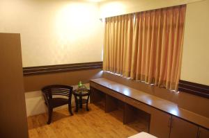 a room with a desk and a chair and a window at Gandhi Inn in Medan