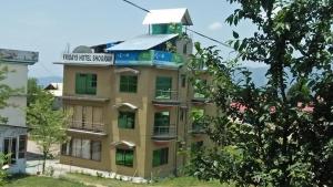 ein Gebäude mit einem Schild darüber in der Unterkunft Fridays Hotel in Shongran