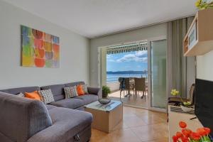 sala de estar con sofá y vistas al océano en Apartments Vranjes Deluxe, en Brela