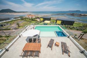 a swimming pool with a table and chairs and the beach at Jeju Attirance in Seogwipo