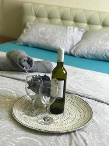 een fles wijn en twee glazen op een bed bij Tresnja in Banja Luka