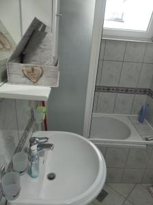 een badkamer met een witte wastafel en een bad bij Tresnja in Banja Luka +15 foto's