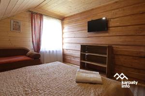 スラブスクにあるСадиба Комфортのベッドルーム1室(ベッド1台、壁掛けテレビ付)