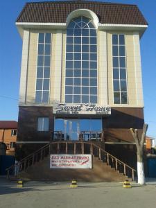 ein großes Gebäude mit einem Schild davor in der Unterkunft Sweet Home Hotel in Atyrau