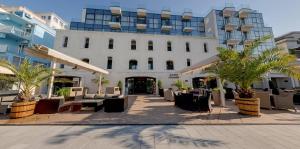 Hotel Antik في بالشيك: فندق فيه طاولات وكراسي امام مبنى
