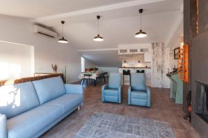 sala de estar con sofá azul y sillas en Ático duplex Touriplaya SOLO FAMILIAS, en Gandía