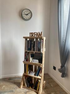 a book shelf with books and a clock on the wall at Azienda Agricola Saint Hubert in Cantalupo Ligure