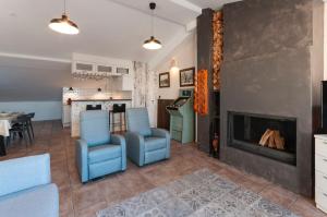 sala de estar con sillas azules y chimenea en Ático duplex Touriplaya SOLO FAMILIAS, en Gandía