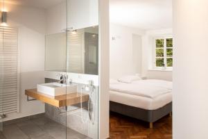 a bedroom with a bed and a sink and a mirror at restaurant271 in Burghausen